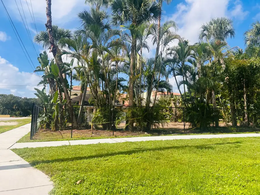 Black temporary fence installed around a landscaped property during renovations
